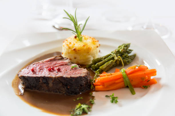 istock Roasted meat with carrots and asparagus on a white plate 686344100