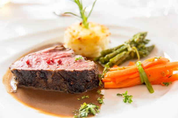 istock Roasted meat with carrots and asparagus on a white plate 686344580