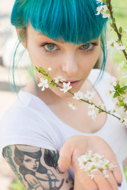 Tattooed young woman with flowers Green hair young woman with tattoo shares flowers black pin up girl tattoos stock pictures, royalty-free photos & images