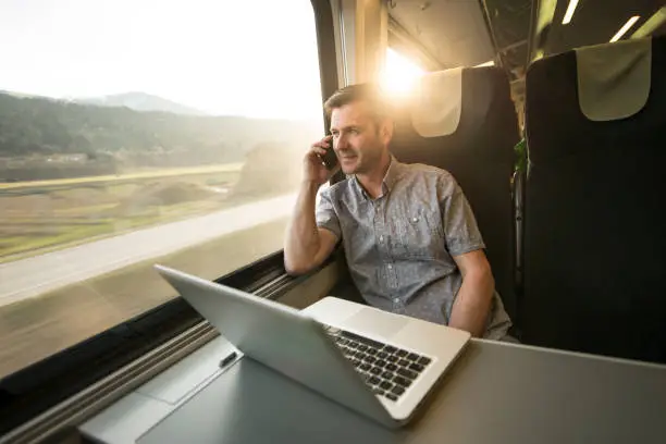 Photo of Businessman working mobile during traveling by train