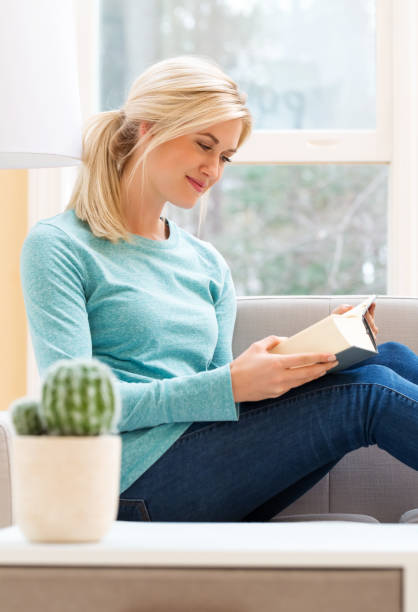 istock Happy young woman reading a book 686360660