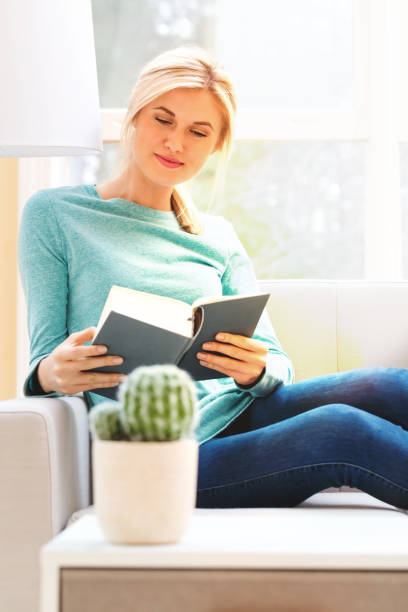 istock Happy young woman reading a book 686360696