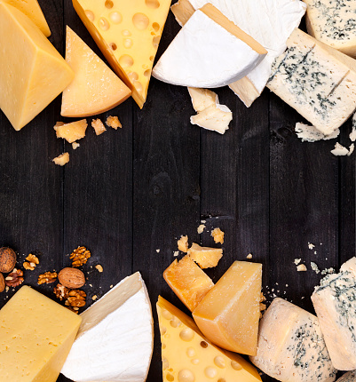 Marco de diferentes tipos de queso sobre mesa negra. Vista superior, copiar espacio. Cheddar, parmesano, Emmental, queso Blu. photo