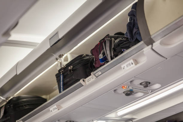 istock Hand luggage into the compartment on the plane 686364116