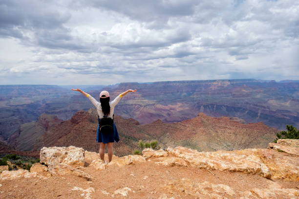 istock Standing on the edge with arms outstreched looking into Grand Canyon 686367228
