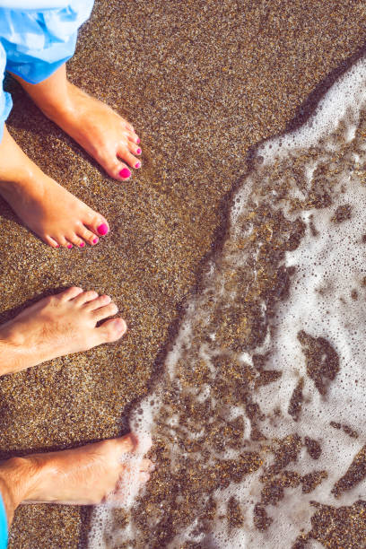 istock Couple standing on shore at beach 686379860