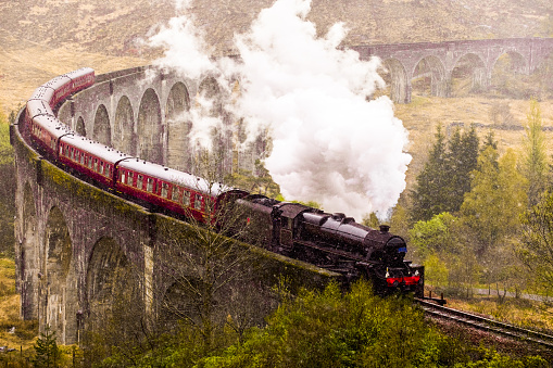 Glenfinnan, Scotland - April 26, 2019: Jacobite Steam Train crossing the  famous Glenfinnan viaduct