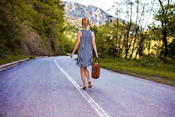 istock Traveler walking with suitcase on road 686383980