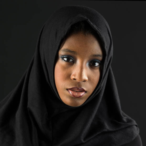 young black muslim woman posing looking at the camera on black background