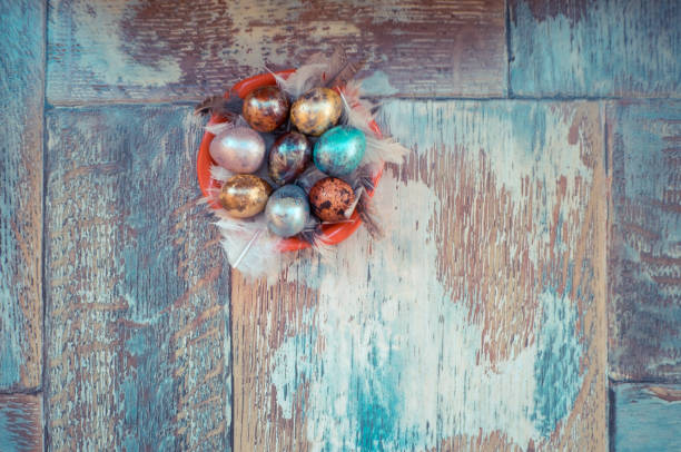 istock On the old wooden shabby table a dish with painted in different colors Easter eggs with feathers willow 686404034