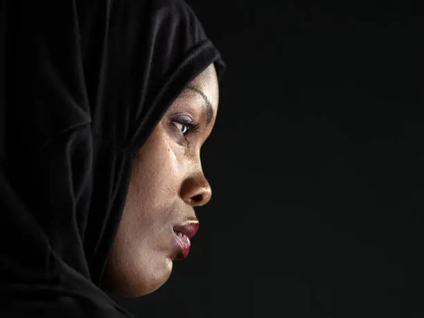 Profile of an African Muslim woman on black background