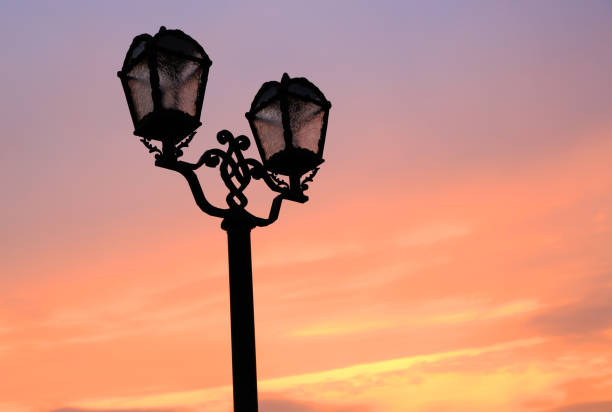 istock old style street lamps on sunset sky background 686412920