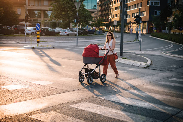 joven madre caminando por la acera peatonal - familia de cruzar la calle fotografías e imágenes de stock