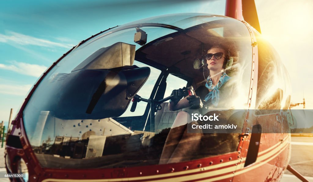 Pilot Attractive woman pilot sitting in the helicopter Helicopter Pilot Stock Photo