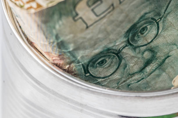 Irish ten punt banknote depicting a sketch of the face of James Joyce (novelist).  The bank note is stuffed into a tin can.