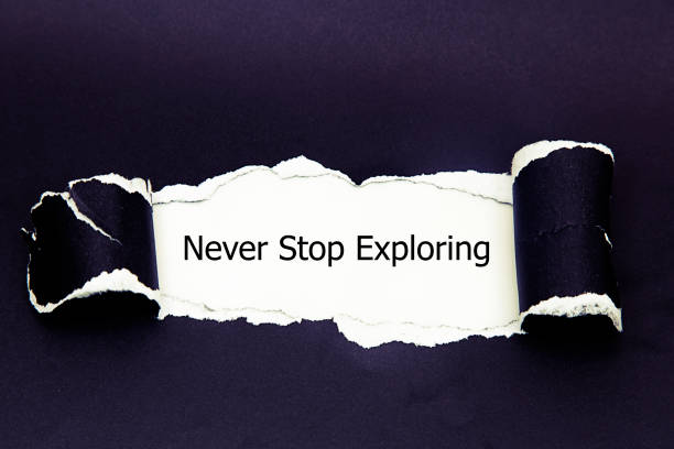 istock The word never stop exploring appearing behind torn paper. 686429050