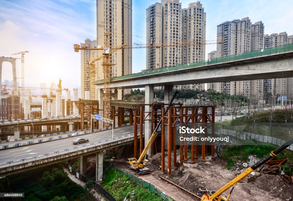 Costruzione di un pilone di cemento alto di ponte con gru a torre - Foto stock royalty-free di Cantiere di costruzione