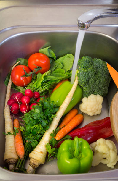 istock Washing fresh seasonal vegetables in the sink 686474094