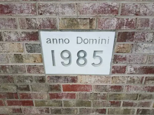 anno domini 1985 sign on red brick wall