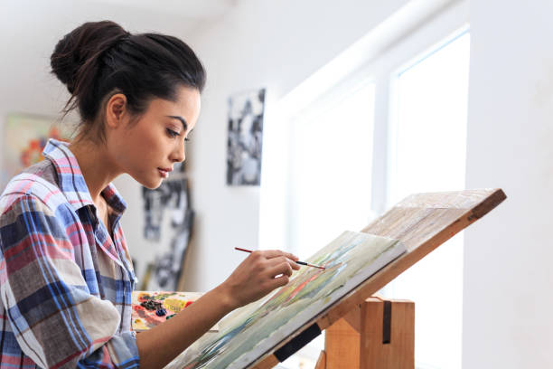 istock Side view of female artists drawning in workshop 686488350