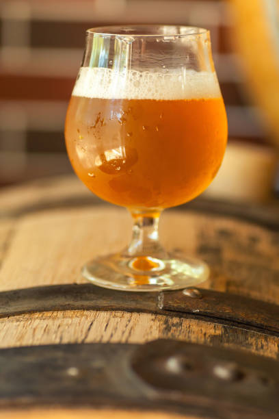 bière légère sur un baril - amber beer photos et images de collection