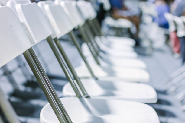 Line of empty foldable white chairs A line of empty foldable white chairs. folding chair stock pictures, royalty-free photos & images