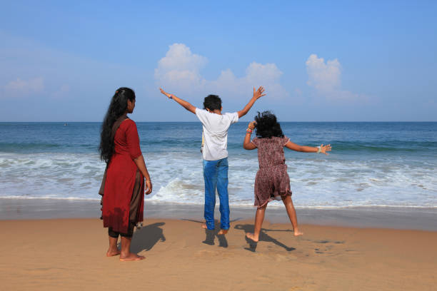 Kids having fun with their mother in Kovalam beach in Kerala.