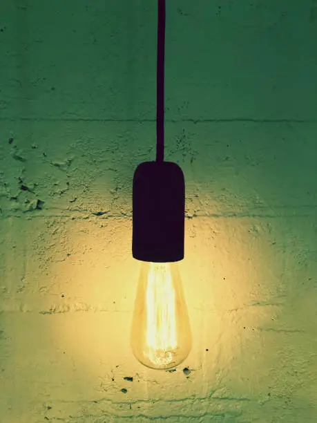 Simple light bulb on a black cord. Design with retro feel.