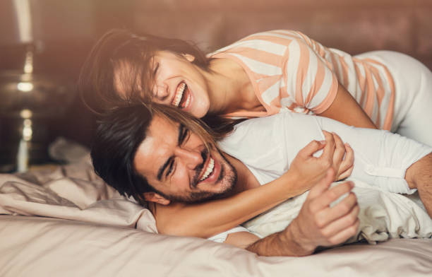 felice giovane coppia a letto - coquette foto e immagini stock