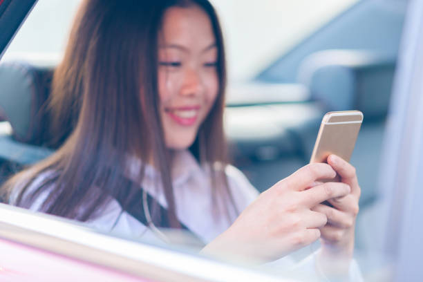 istock Chinese young woman using smart phone in the car. 686511758
