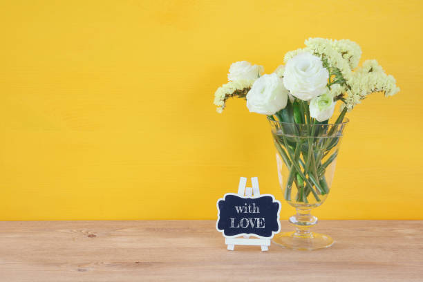 istock top view of white spring flowers on wooden background 686516122