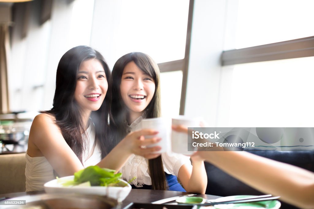 happy Group of girl friends toasting and eating in the restaurant Eating Stock Photo