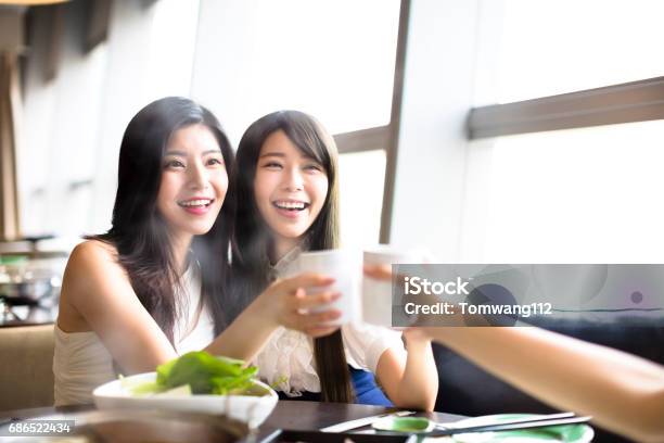 Happy Group Of Girl Friends Toasting And Eating In The Restaurant Stock Photo - Download Image Now