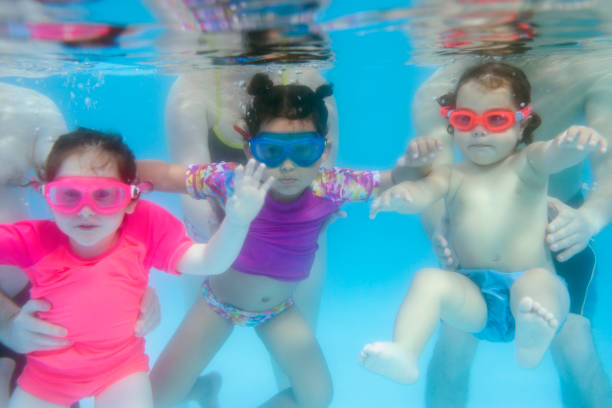 istock Little kids with parents on swimming lesson. 686522514