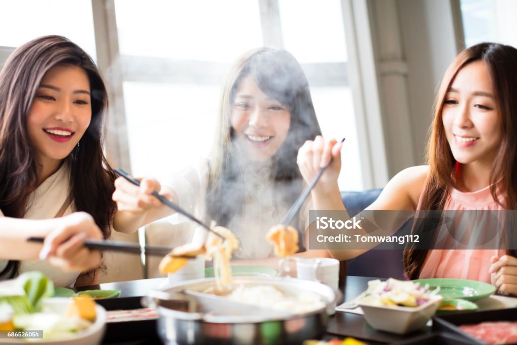 幸せな若い女性グループ鍋を�食べる - 食べるのロイヤリティフリーストックフォト