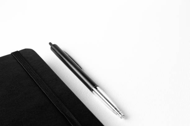 Pen an notepad isolated on a white canvas background with selective focusing on pen.