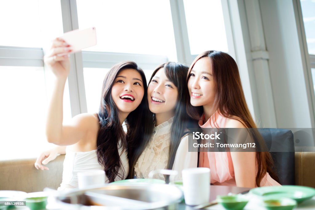 feliz jovem namorada tomar selfie juntos no restaurante - Foto de stock de Amizade royalty-free