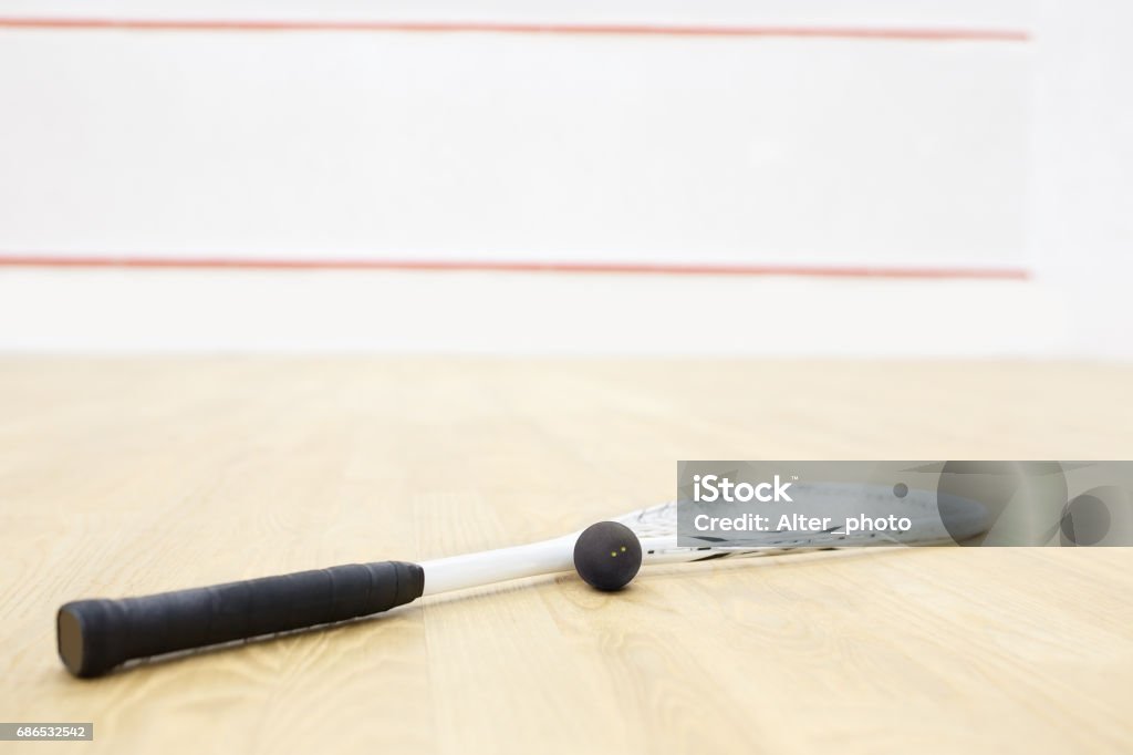 squash racket and ball squash racket and ball. Racquetball equipment on the court and wall with red lines on the background. Photo with selective focus Active Lifestyle Stock Photo