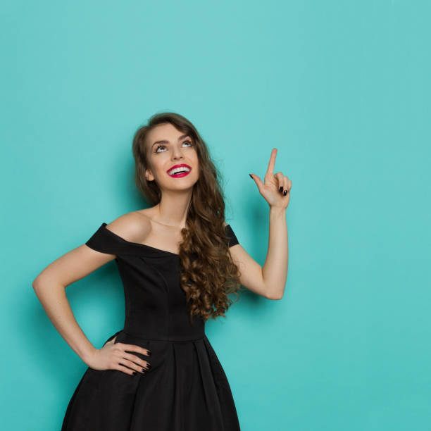 istock Elegant Young Woman Is Smiling, Looking Up And Pointing 686533064