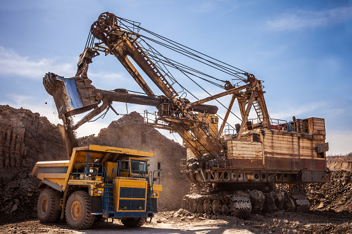 Excavator loading dump truck at coal mining