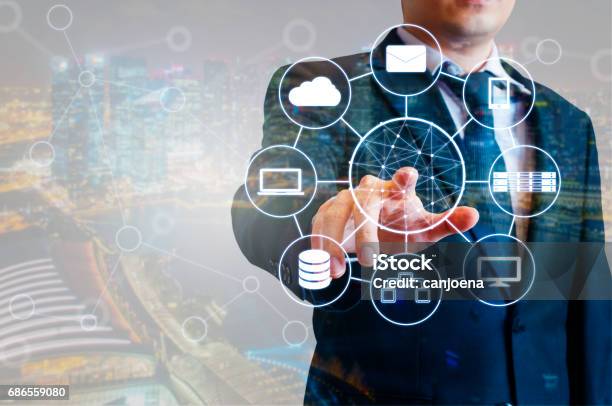 Double Exposure Of Professional Businessman Connected Devices With World Digital Technology Internet And Wireless Network On Touch Screen And City Of Business Background In Business And Technology Concept Stock Photo - Download Image Now