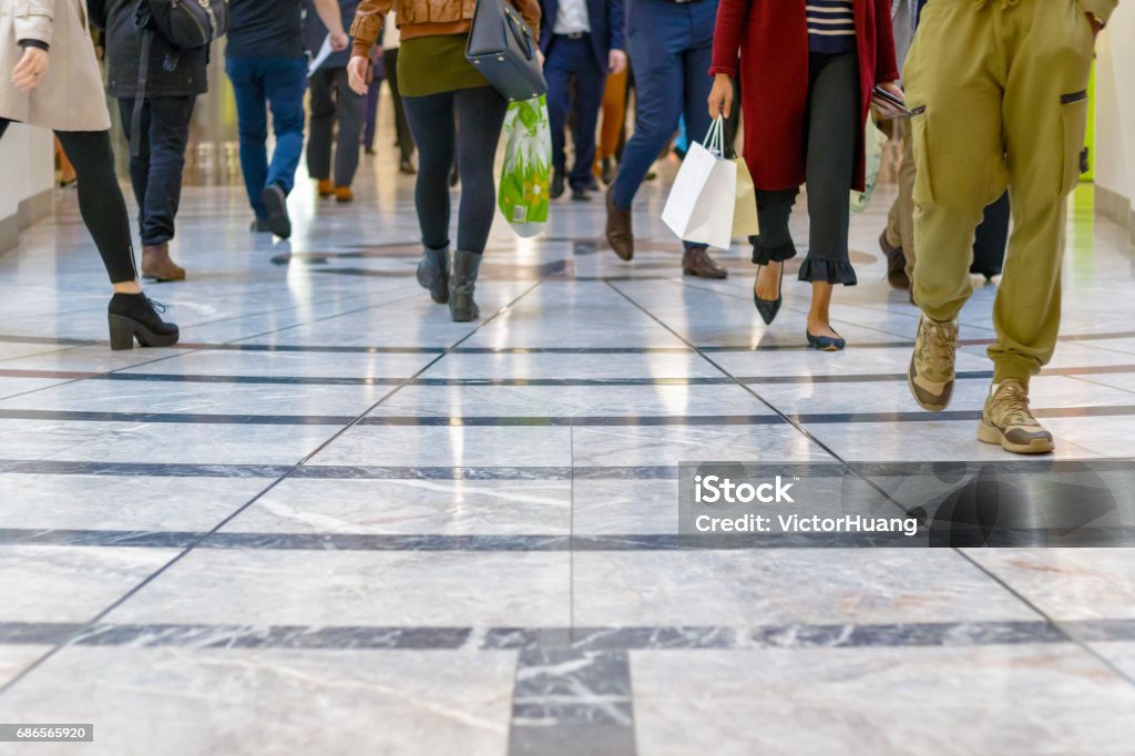 A modern floor with legs of a crowd walking in the background A modern floor with legs of a crowd walking in a shopping mall in the background Shopping Mall Stock Photo