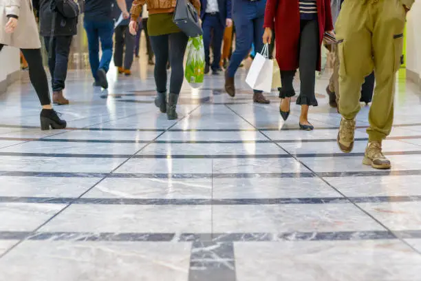 Photo of A modern floor with legs of a crowd walking in the background