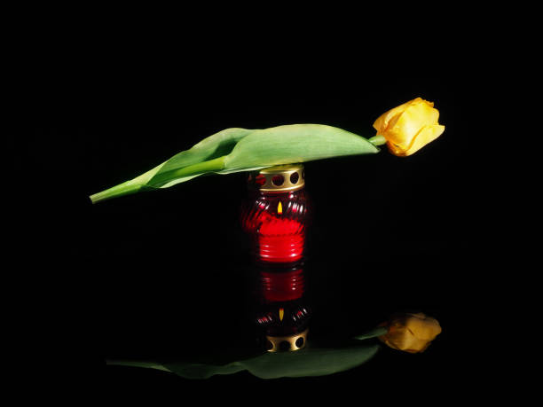 Burning candle in a red glass candlestick