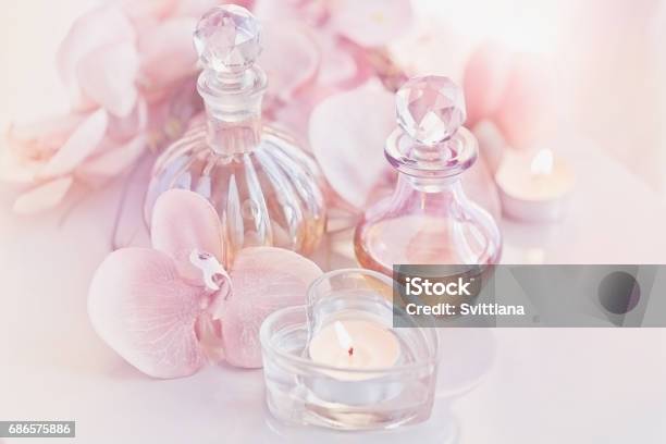 Botellas De Aceites De Perfume Y Aromático Rodeadas De Flores Y Cand Foto de stock y más banco de imágenes de Aceites esenciales