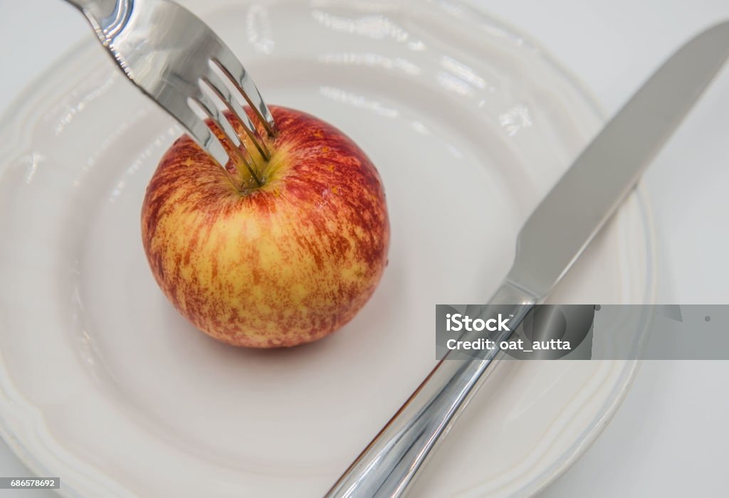 Pomme rouge sur l’assiette et une fourchette, couteau sur fond blanc - Photo de Acier libre de droits