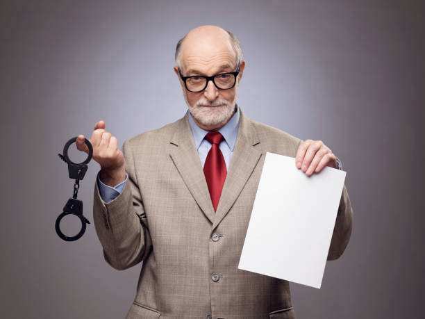 istock Senior man with handcuffs and paper 686588314