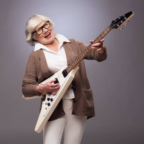 senior woman playing electric guitar - guitarist one person caucasian adult imagens e fotografias de stock