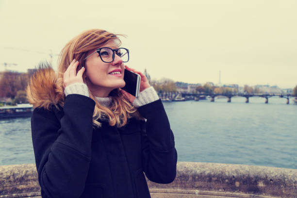 istock Girl using cellphone near the river Seine in Paris. 686591008