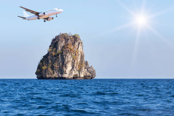 istock airplane flying above small island in blue sea 686594378